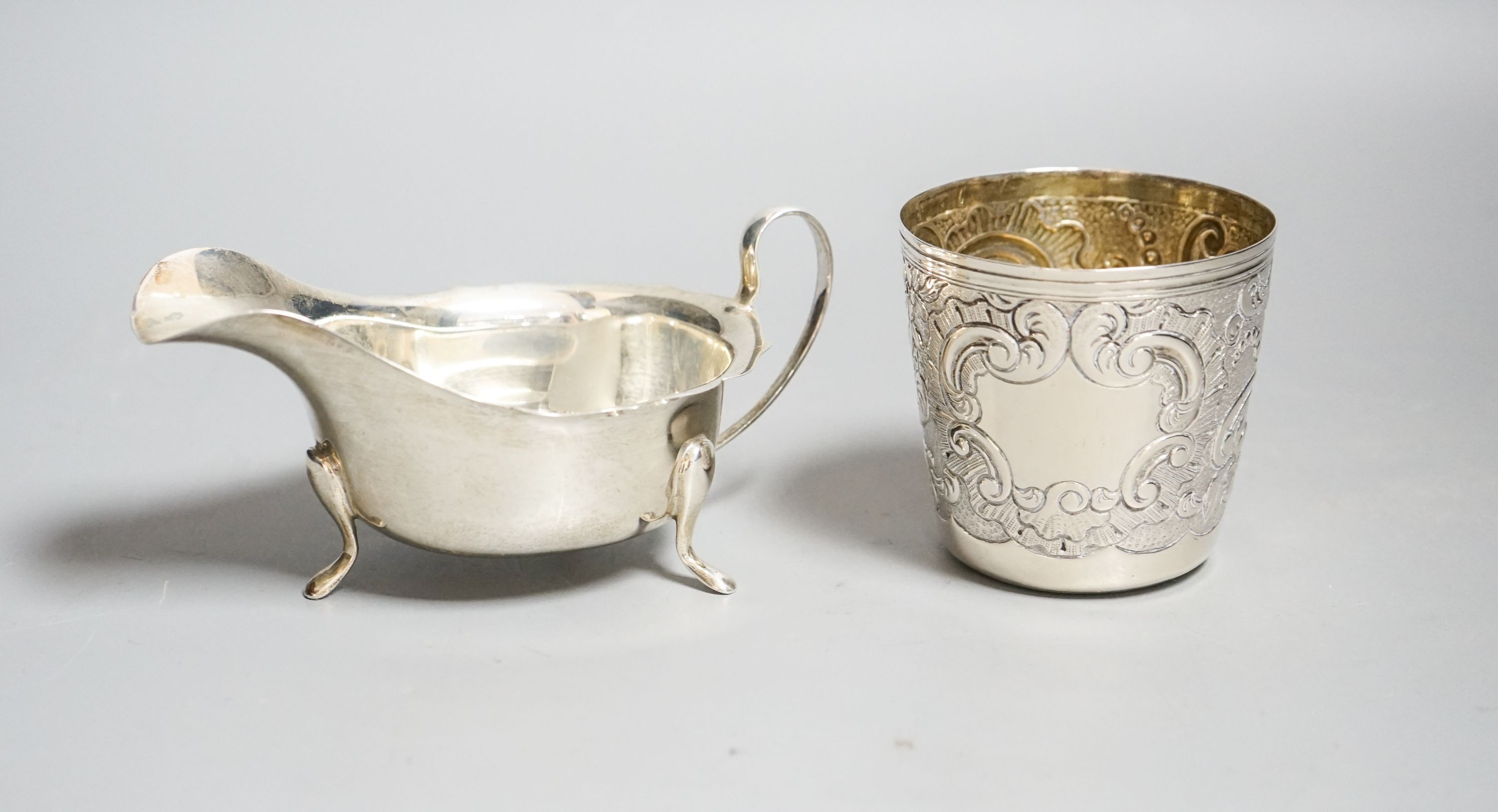 A 19th century Portuguese white metal tumbler, 7cm and a later silver sauceboat, 6.5oz.